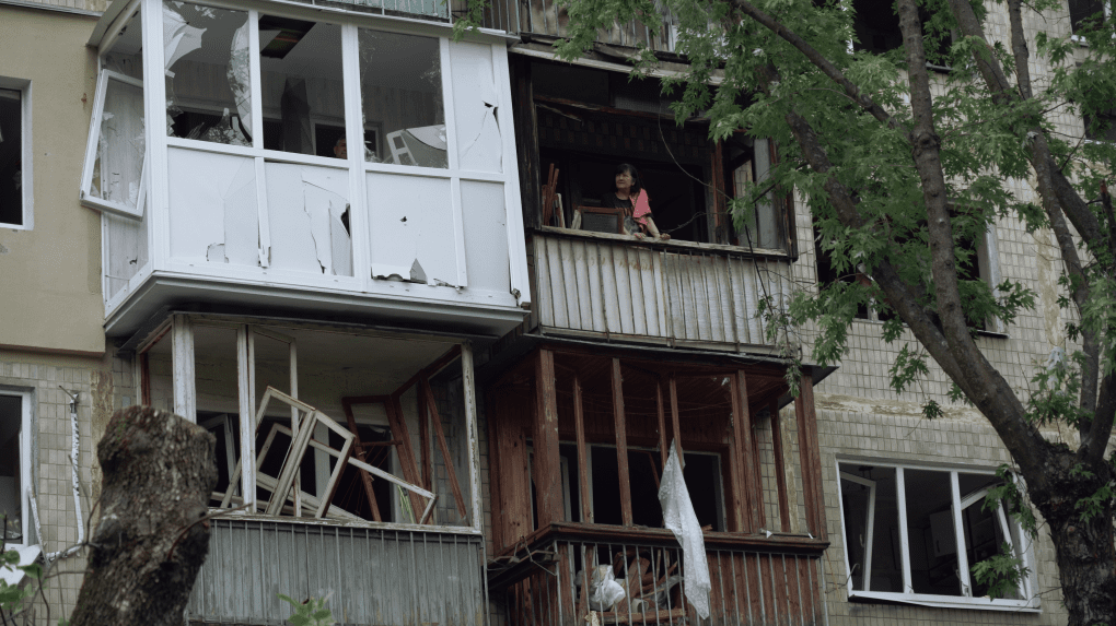 Residents look out from the shattered windows of their destroyed apartments. (Source: UNITED24 Media) Residents look out from the shattered windows of their destroyed apartments. (Source: UNITED24 Media)